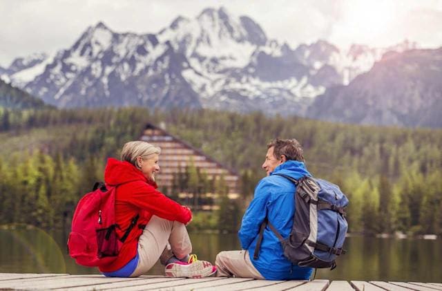 Two people sitting on a dock with backpacks